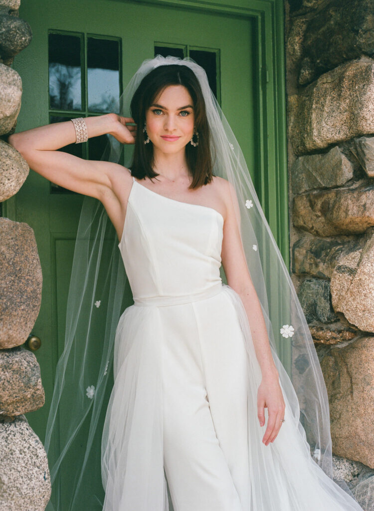 Bride poses in edgy wedding jumpsuit  for film wedding photography