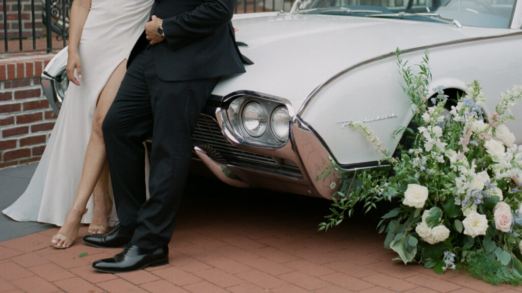 Couple stands in front of vintage car on wedding day - film wedding photography
