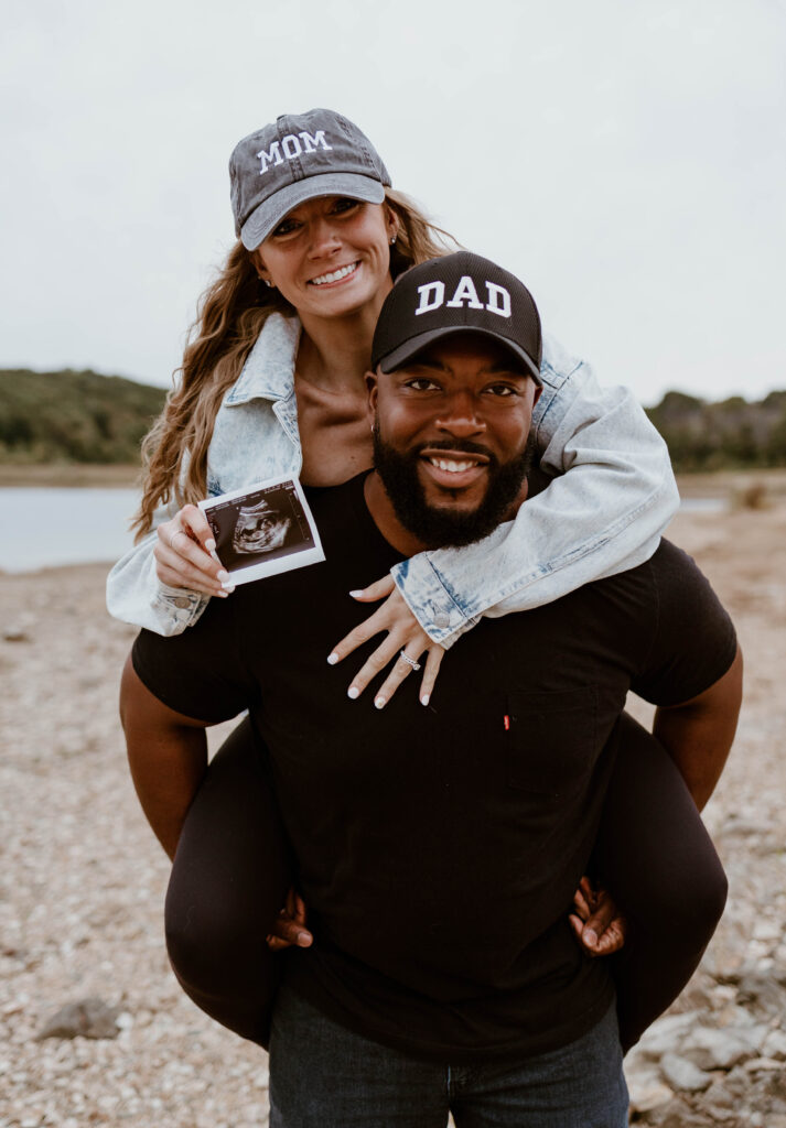 Husband and wife wear mom and dad hats during fun pregnancy announcement photoshoot