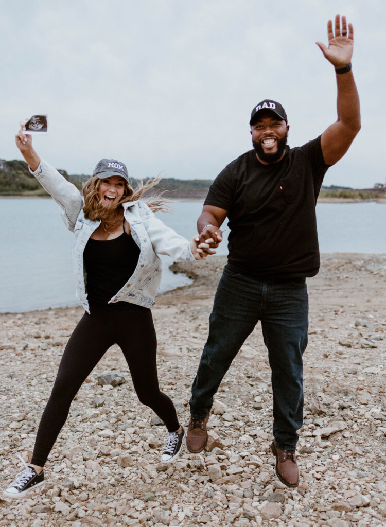 Husband and wife jump in the air with excitement at fun pregnancy announcement photoshoot