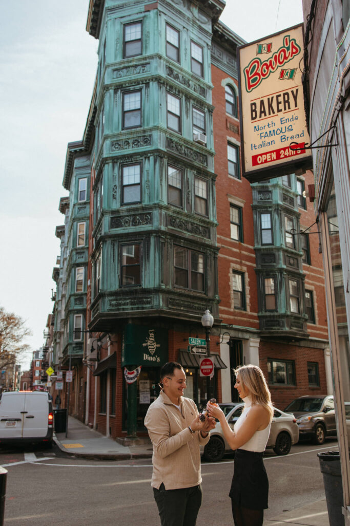 Couple shares Cannoli outside Bova's Bakery in Boston North End Engagement Photos