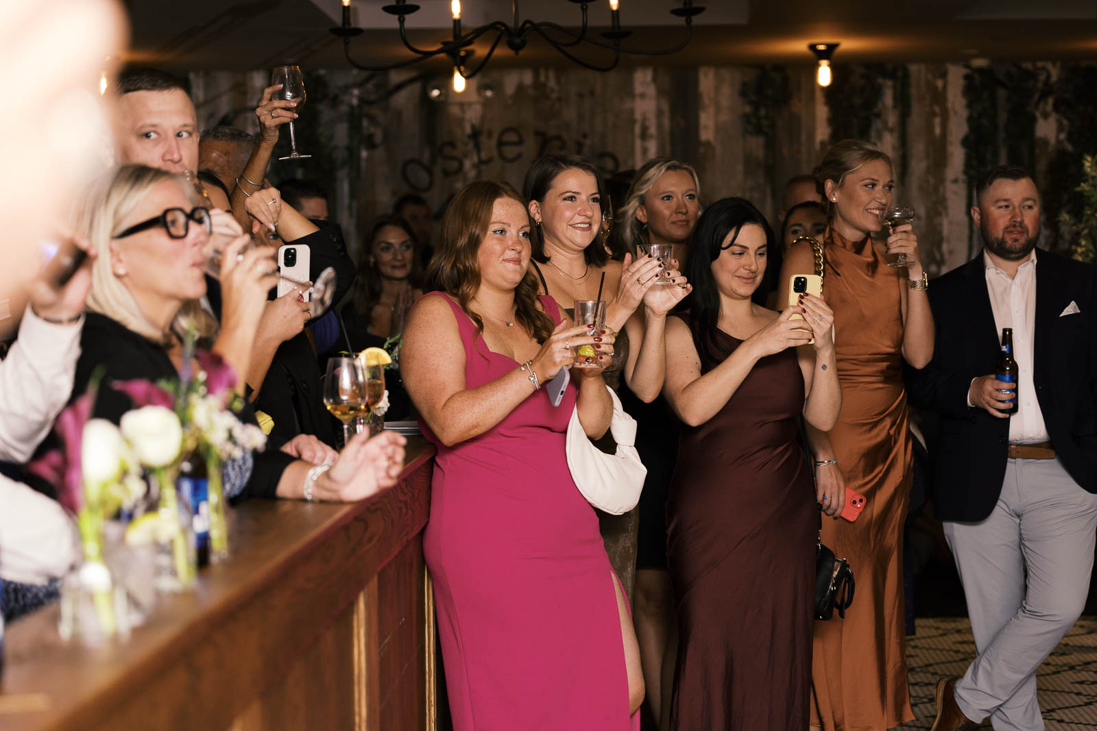 Guests take photos on their photos at intimate restaurant wedding