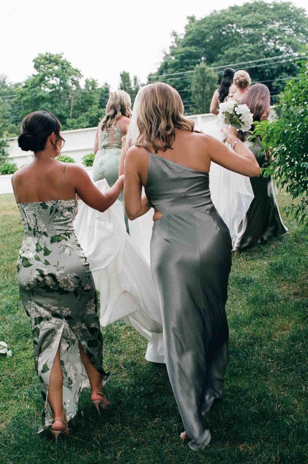 Bridesmaids carry the wedding dress of the bride