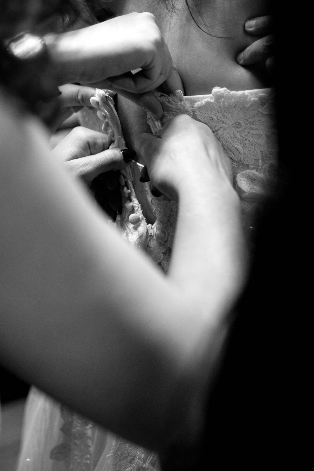 Bridesmaids help bride get dressed before umass club wedding